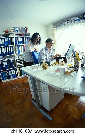 Stock Photo - Couple using computer in study room. Fotosearch
