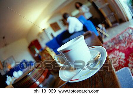 Cup on saucer, couple in the background View Large Photo Image Stock Photo - Cup on saucer, couple in the background. Fotosearch