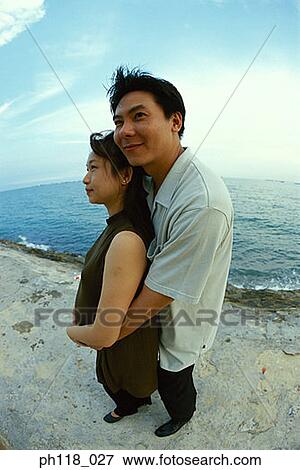 Stock Photo - Portrait of a man hugging a pregnant woman . Fotosearch