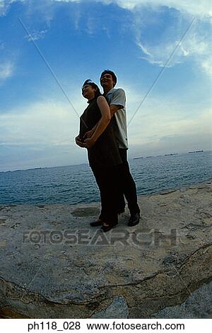 Stock Photo - Portrait of a man hugging a pregnant woman . Fotosearch