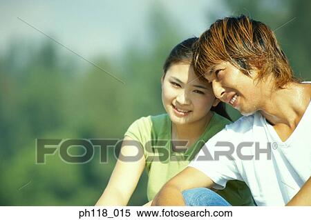 Stock Photography - Portrait of a young couple in a park . Fotosearch