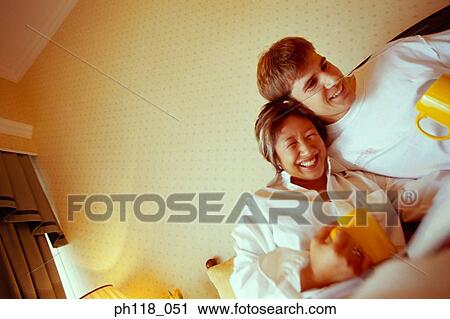 Portrait of a young couple on bed, smiling View Large Photo Image Stock Image - Portrait of a young couple on bed, smiling. Fotosearch