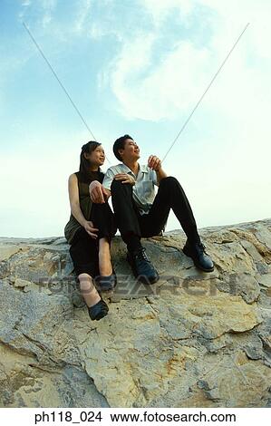 Young couple sitting on water breaker View Large Photo Image Picture - Young couple sitting on water breaker. Fotosearch