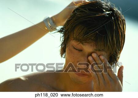 Stock Image - Young man rubbing his eyes. Fotosearch