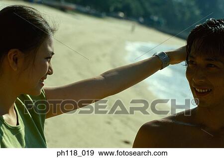 Young woman touches man's head View Large Photo Image Stock Photo - Young woman touches man's head. Fotosearch