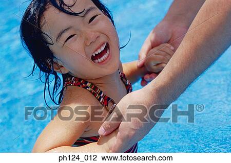 Parent holding young Asian girl in the pool, laughing View Large Photo Image Stock Image - Parent holding young Asian girl in the pool, laughing. Fotosearch