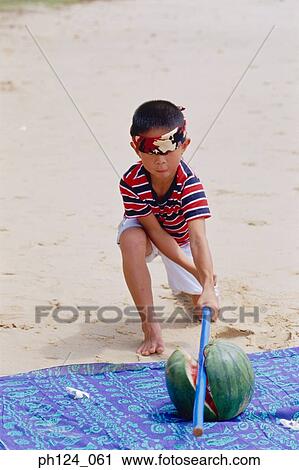 Young Asian boy blind folded, broke a watermelon with a stick View Large Photo Image Stock Image - Young Asian boy blind folded, broke a watermelon with a stick. Fotosearch