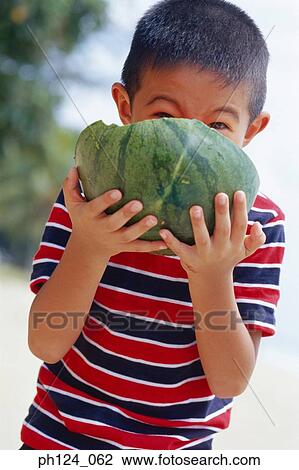 Stock Image - Young Asian boy eating watermelon. Fotosearch