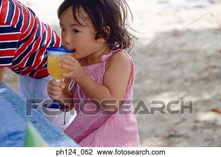 Young Asian girl drinking juice from glass View Large Photo Image Stock Image - Young Asian girl drinking juice from glass. Fotosearch