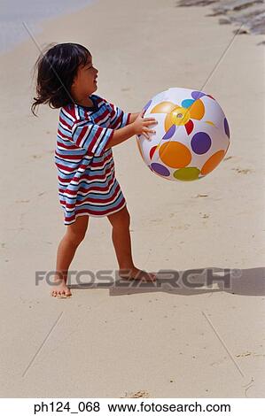 Young Asian girl holding a beach ball at the beach Stock Photo | ph124