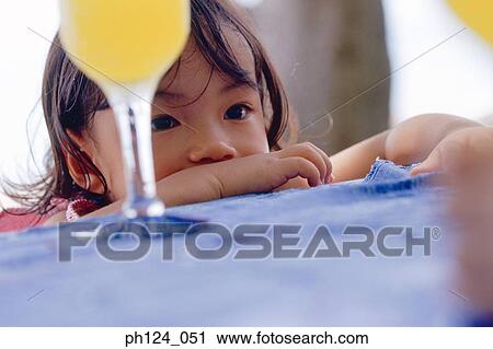 Young Asian girl resting her arms on table View Large Photo Image Stock Image - Young Asian girl resting her arms on table. Fotosearch