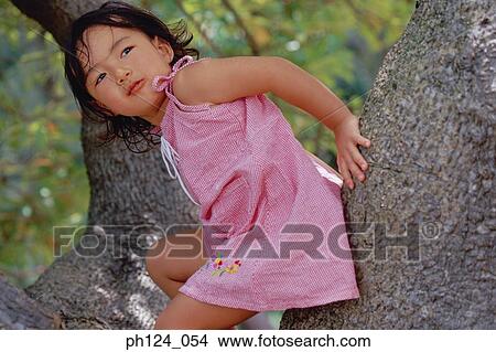 Young Asian girl sitting on tree trunk View Large Photo Image Picture - Young Asian girl sitting on tree trunk. Fotosearch