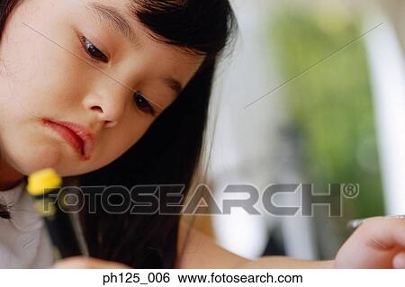 Stock Photograph - Portrait of a young girl writing. Fotosearch