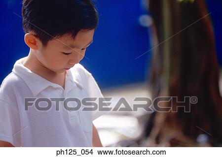 Young Asian boy looking down, portrait View Large Photo Image Picture - Young Asian boy looking down, portrait. Fotosearch