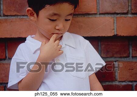Stock Photography - Young Asian boy looking down, portrait. Fotosearch