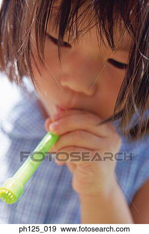 Young Asian girl blowing soap bubbles View Large Photo Image Stock Photo - Young Asian girl blowing soap bubbles. Fotosearch