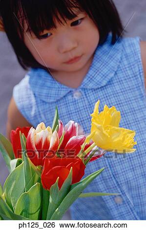 Young Asian girl looking at a bunch of flowers View Large Photo Image Stock Photograph - Young Asian girl looking at a bunch of flowers. Fotosearch
