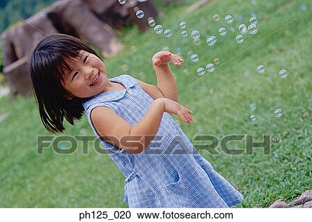 Young Asian girl playing with bubbles View Large Photo Image Stock Image - Young Asian girl playing with bubbles. Fotosearch