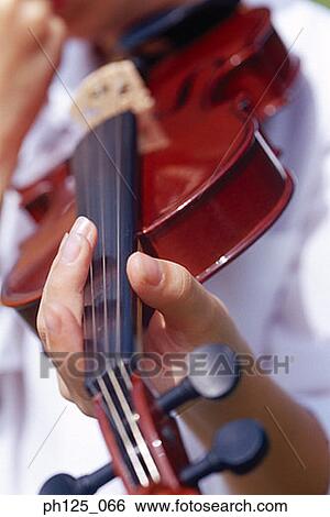 Stock Photograph - Young boy holding a violin, close-up. Fotosearch