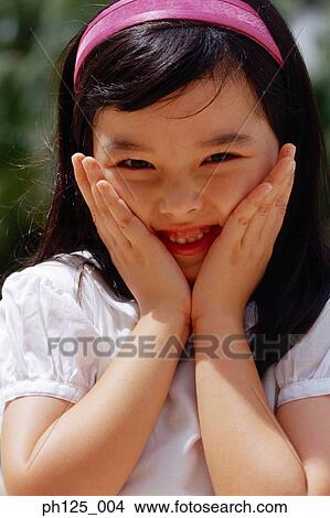 Young girl with her hands on her face, close-up View Large Photo Image Picture - Young girl with her hands on her face, close-up. Fotosearch