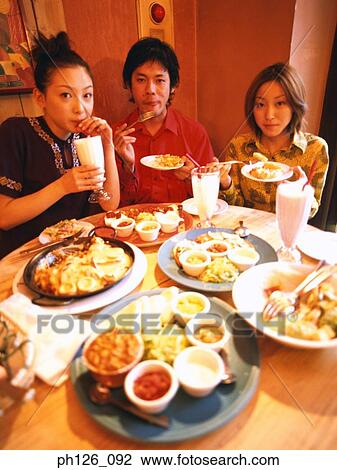 Friends dining at a café View Large Photo Image Stock Image - Friends dining at a café. Fotosearch
