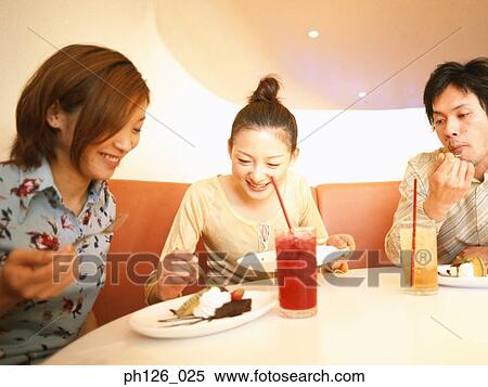 Friends eating desserts at a café View Large Photo Image Stock Photography - Friends eating desserts at a café. Fotosearch