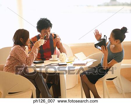 Friends gathering at a café View Large Photo Image Stock Photo - Friends gathering at a café. Fotosearch