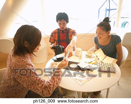 Friends gathering at a café View Large Photo Image Stock Photo - Friends gathering at a café. Fotosearch