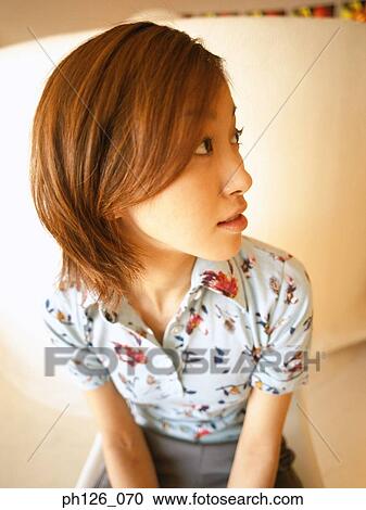 Stock Image - Portrait of a young woman, looking away. Fotosearch