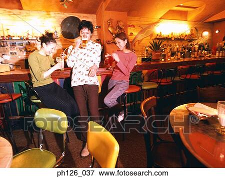 Three young adults at bar counter View Large Photo Image Stock Photo - Three young adults at bar counter. Fotosearch