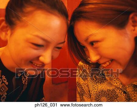 Stock Image - Two young women smiling, close up. Fotosearch