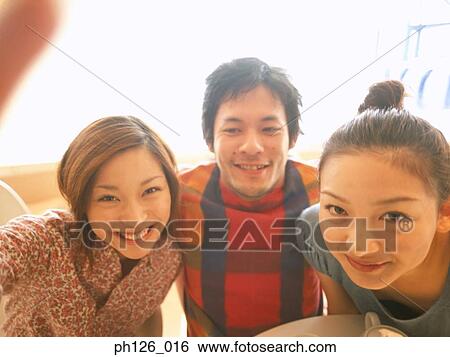 Stock Photograph - Young adults posing for picture taking. Fotosearch