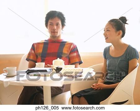 Young couple chatting at a café View Large Photo Image Stock Photography - Young couple chatting at a café. Fotosearch