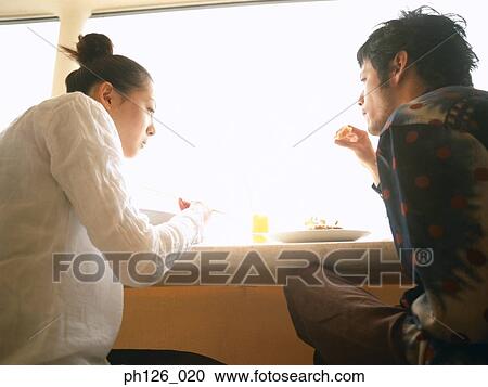 Young couple eating at a café View Large Photo Image Stock Image - Young couple eating at a café. Fotosearch