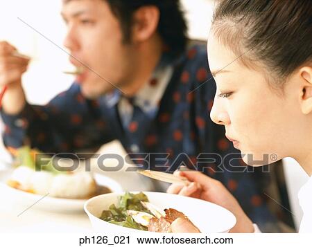 Young couple eating at a café View Large Photo Image Stock Image - Young couple eating at a café. Fotosearch
