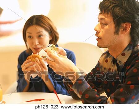 Young couple eating at a café View Large Photo Image Stock Image - Young couple eating at a café. Fotosearch