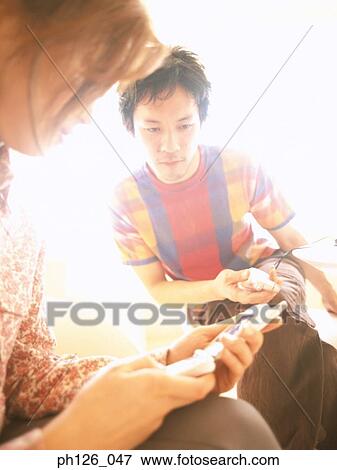Stock Photo - Young couple holding mobile phones. Fotosearch