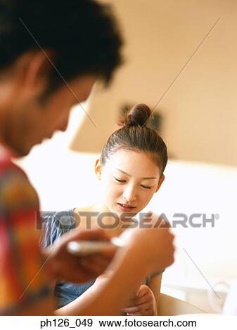 Young couple holding mobile phones View Large Photo Image Stock Photo - Young couple holding mobile phones. Fotosearch