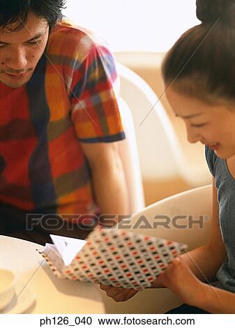 Young couple looking at photo album View Large Photo Image Stock Image - Young couple looking at photo album. Fotosearch