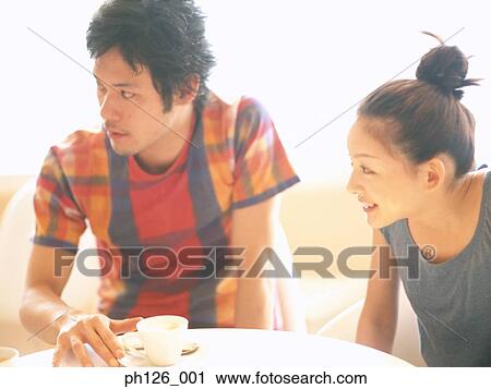 Stock Image - Young couple sitting at a café. Fotosearch
