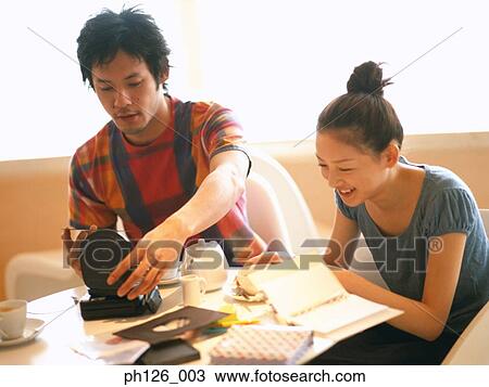 Young couple sitting at a café View Large Photo Image Stock Image - Young couple sitting at a café. Fotosearch