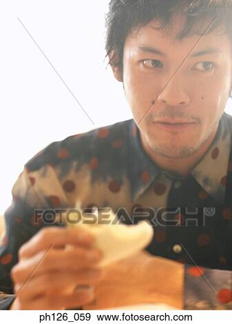Young man eating sandwich View Large Photo Image Stock Photo - Young man eating sandwich. Fotosearch