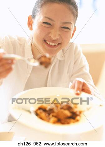 Young woman attempting to feed photographer View Large Photo Image Stock Image - Young woman attempting to feed photographer. Fotosearch