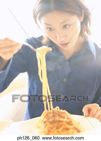 Young woman eating pasta with fork View Large Photo Image Stock Image - Young woman eating pasta with fork. Fotosearch
