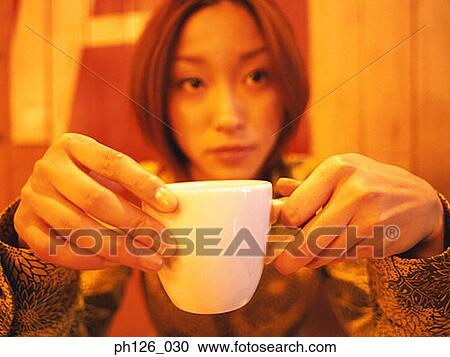 Young woman holding a coffee cup View Large Photo Image Stock Image - Young woman holding a coffee cup. Fotosearch