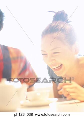 Young woman laughing at a café, close up View Large Photo Image Stock Photo - Young woman laughing at a café, close up. Fotosearch