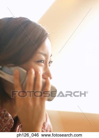 Young woman talking on mobile phone View Large Photo Image Stock Photograph - Young woman talking on mobile phone. Fotosearch