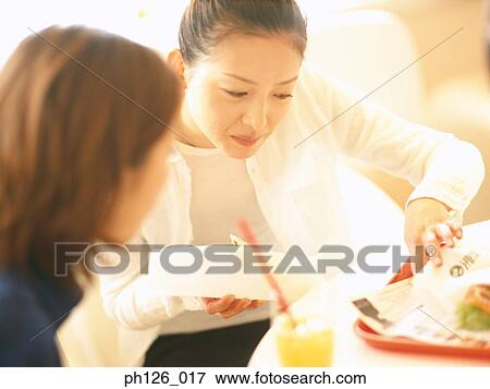 Stock Photo - Young women at a café. Fotosearch