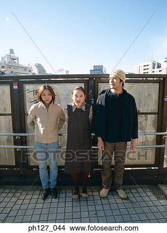 Friends leaning against railing View Large Photo Image Picture - Friends leaning against railing. Fotosearch