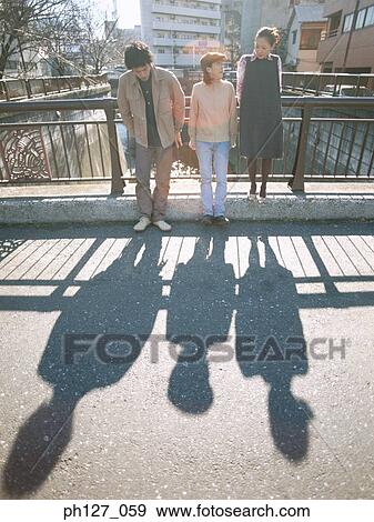 Stock Photo - Friends leaning against railing. Fotosearch
